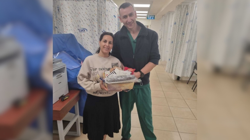 אלכס חשפר מנהל המוקד של מכבי יחד עם המטופלת | צילום: מכבי