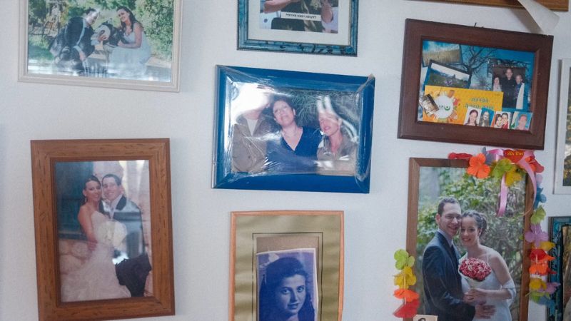 הקיר המכוסה בתמונות הנכדים של סימה בתיה פרידמן | צילום: עומר מוזר