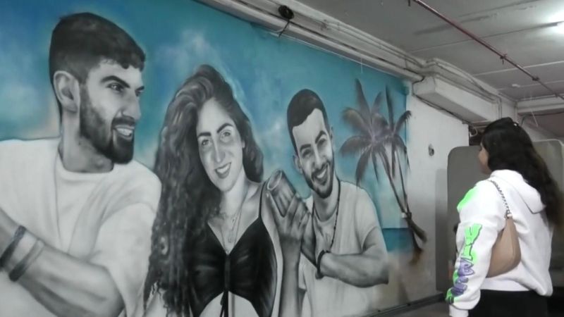 מורין אוחיון וציור הקיר המנציח את אחותי עדן ליז אוחיון, את בן הדוד ירין אפריים וחברו אוראל אבוחצירה | צילום: מתוך הסרט