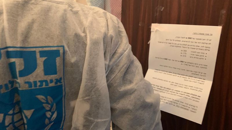 מכתב על חוב לוועד הבית על דלת דירתו של קשיש ערירי שנפטר | צילום: דוברות זק"א