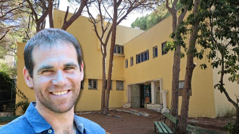 מורן אופק, חבר הנהלת עמותת יד ביד, על רקע מבנה הגנים הדו לשוניים במרכז הכרמל | צילומים: עמותת יד ביד