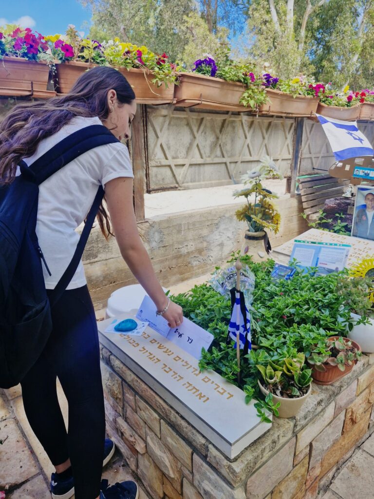 תלמידת חוגים מניחה מכתב בבית העלמין הצבאי בחיפה | צילום: דוברות עיריית חיפה