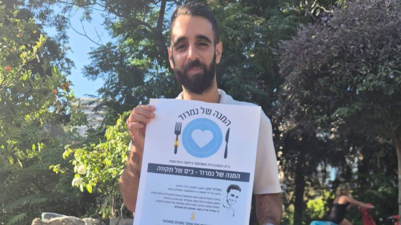 בן, מנהל ויוינו חיפה עם השלט של