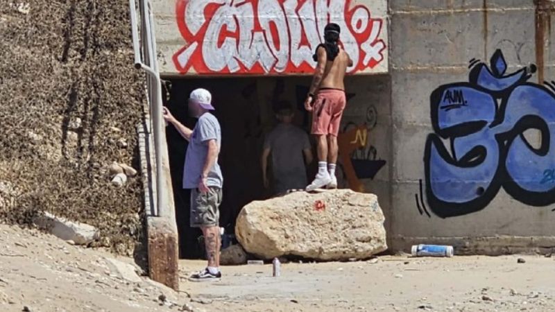 הנערים שנתפסו על חם מציירים על קירות המנהרה בחוף הים | צילום: דוברות עיריית חיפה
