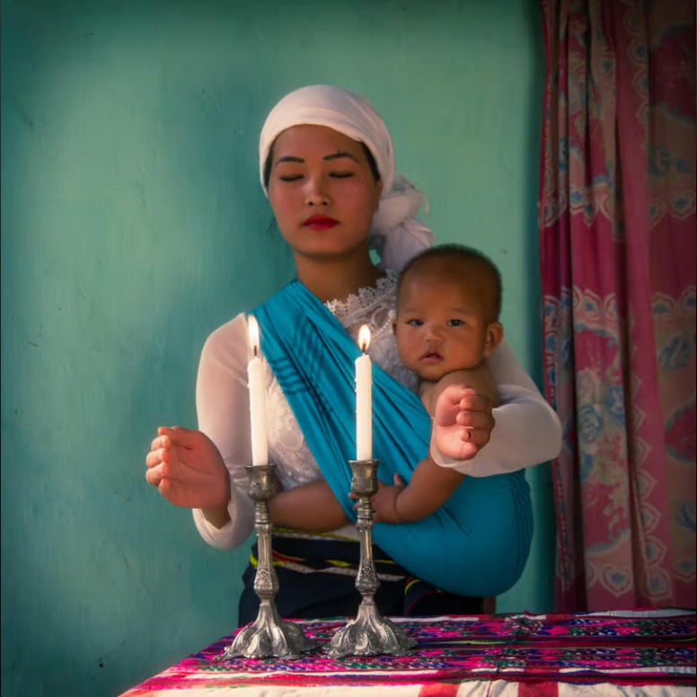 אמא מקהילת בני המנשה מדליקה נרות שבת | צילום: דורית לומברוזו