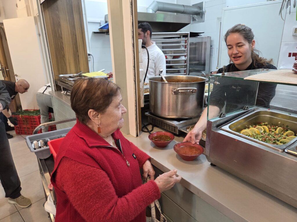 אלה דשבסקה מגישה מרק חם לשורדת שבי | צילום: מדיה ודיגיטל עמותת יד עזר לחבר