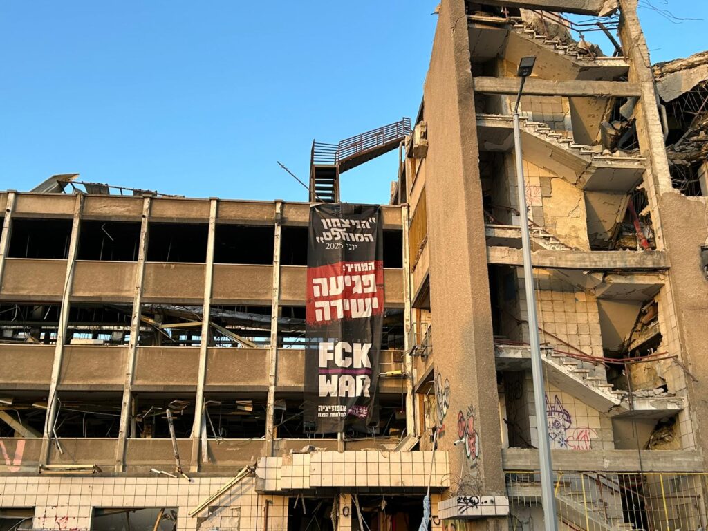 השלט שנתלה על בניין בזק הישן בעיר התחתית שנפגע מטיל איראני | צילום: תנועת עומדים ביחד